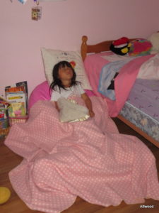 Her reading chair with a pile of stuffies under her feet.